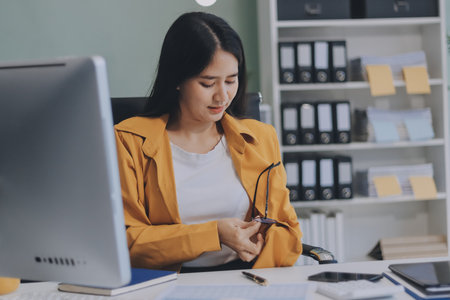 Business woman using calculator for do math finance on wooden desk in office and business working background, tax, accounting, statistics and analytic research concept.の写真素材