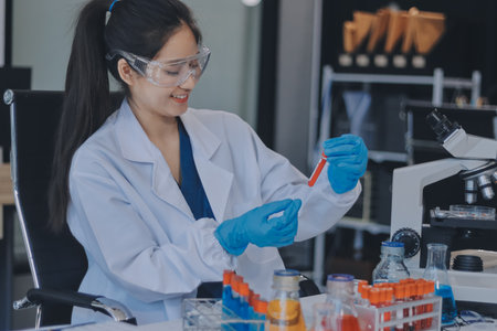 Portrait, science and happy woman on laptop in lab to research chemistry, test or innovation. Microscope, scientist and face of medical doctor in goggles for microbiology, healthcare or pharma studyの写真素材