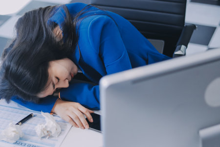 Business woman having headache at officeの写真素材