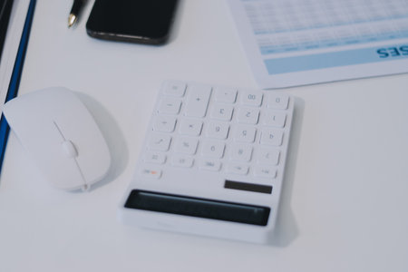 Wooden work desk with laptop and documents, books, modern interior of cozy cabinet, table for businessman or student at home, comfortable workspace, workplace with computer in apartmentの写真素材