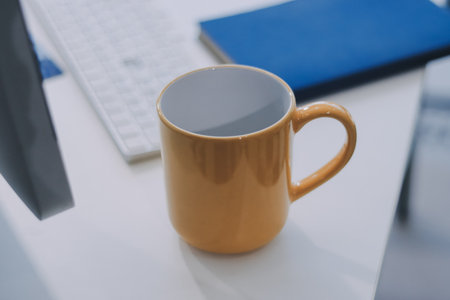 Wooden work desk with laptop and documents, books, modern interior of cozy cabinet, table for businessman or student at home, comfortable workspace, workplace with computer in apartmentの写真素材