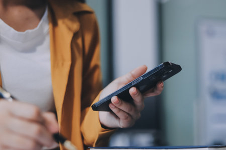 Business woman using calculator for do math finance on wooden desk in office and business working background, tax, accounting, statistics and analytic research concept.の写真素材