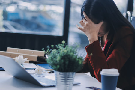 tired business woman sleepy and bored from sitting at a desk for a long time and has office syndromeの写真素材
