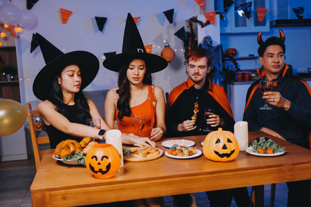 Joyful Halloween party with coworkers in costumes, celebrating with drinks and laughter, fostering teamwork and festive spiritの写真素材