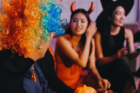 Joyful office Halloween party with coworkers in costumes, celebrating with drinks and laughter,...