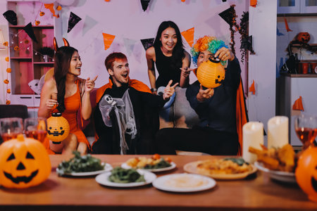 Joyful Halloween party with coworkers in costumes, celebrating with drinks and laughter, fostering teamwork and festive spiritの写真素材