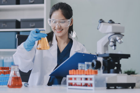 Portrait, science and happy woman on laptop in lab to research chemistry, test or innovation. Microscope, scientist and face of medical doctor in goggles for microbiology, healthcare or pharma studyの写真素材