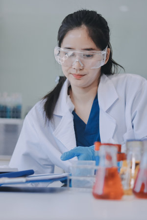 Portrait, science and happy woman on laptop in lab to research chemistry, test or innovation. Microscope, scientist and face of medical doctor in goggles for microbiology, healthcare or pharma studyの写真素材
