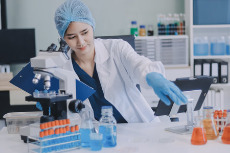 Portrait, science and happy woman on laptop in lab to research chemistry, test or innovation. Microscope, scientist and face of medical doctor in goggles for microbiology, healthcare or pharma studyの写真素材