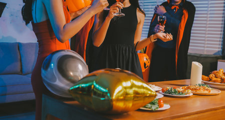 Joyful office Halloween party with coworkers in costumes, celebrating with drinks and laughter, fostering teamwork and festive spiritの写真素材