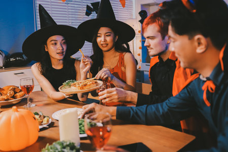 Joyful Halloween party with coworkers in costumes, celebrating with drinks and laughter, fostering teamwork and festive spiritの写真素材