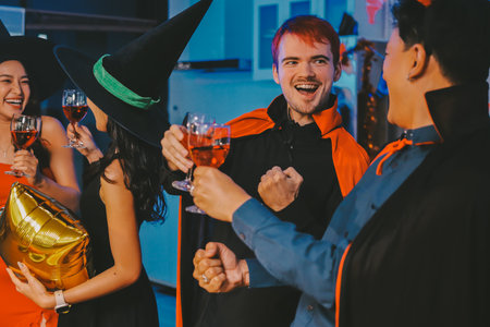 Joyful office Halloween party with coworkers in costumes, celebrating with drinks and laughter, fostering teamwork and festive spiritの写真素材