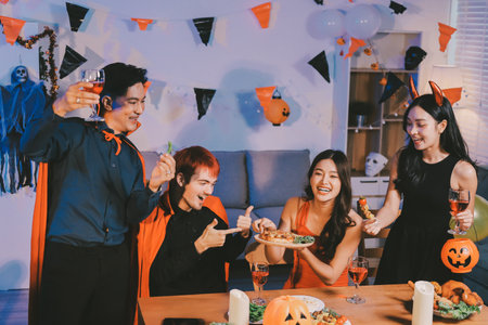 Joyful Halloween party with coworkers in costumes, celebrating with drinks and laughter, fostering teamwork and festive spiritの写真素材