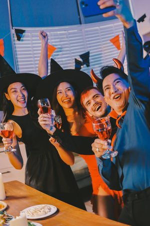 Joyful office Halloween party with coworkers in costumes, celebrating with drinks and laughter, fostering teamwork and festive spiritの写真素材