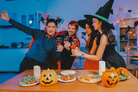 Joyful office Halloween party with coworkers in costumes, celebrating with drinks and laughter, fostering teamwork and festive spiritの写真素材
