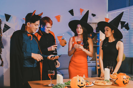Joyful Halloween party with coworkers in costumes, celebrating with drinks and laughter, fostering teamwork and festive spiritの写真素材