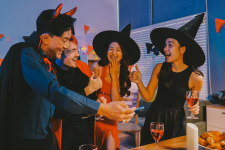 Joyful office Halloween party with coworkers in costumes, celebrating with drinks and laughter, fostering teamwork and festive spiritの写真素材