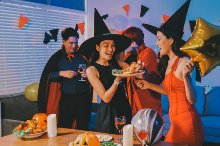 Joyful Halloween party with coworkers in costumes, celebrating with drinks and laughter, fostering teamwork and festive spiritの写真素材