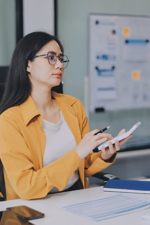Business woman using calculator for do math finance on wooden desk in office and business working background, tax, accounting, statistics and analytic research concept.の写真素材