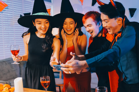 Joyful Halloween party with coworkers in costumes, celebrating with drinks and laughter, fostering teamwork and festive spiritの写真素材