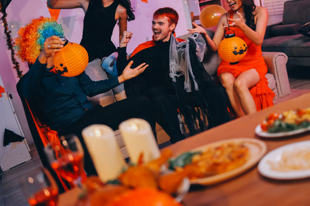 Joyful Halloween party with coworkers in costumes, celebrating with drinks and laughter, fostering teamwork and festive spiritの写真素材