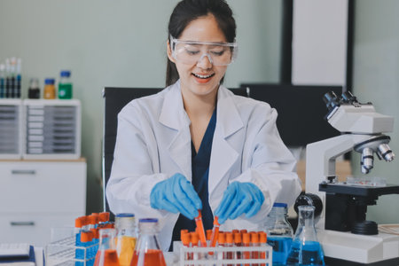 Portrait, science and happy woman on laptop in lab to research chemistry, test or innovation. Microscope, scientist and face of medical doctor in goggles for microbiology, healthcare or pharma studyの写真素材