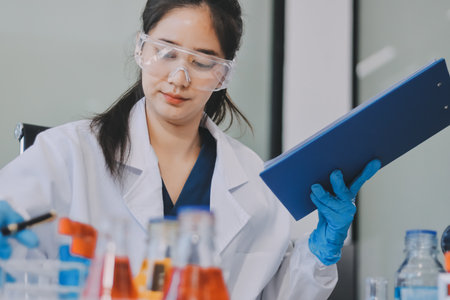 Portrait, science and happy woman on laptop in lab to research chemistry, test or innovation. Microscope, scientist and face of medical doctor in goggles for microbiology, healthcare or pharma studyの写真素材