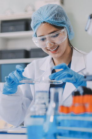 Portrait, science and happy woman on laptop in lab to research chemistry, test or innovation. Microscope, scientist and face of medical doctor in goggles for microbiology, healthcare or pharma studyの写真素材