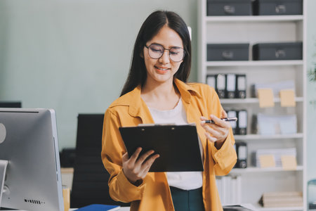 Business woman using calculator for do math finance on wooden desk in office and business working background, tax, accounting, statistics and analytic research concept.の写真素材