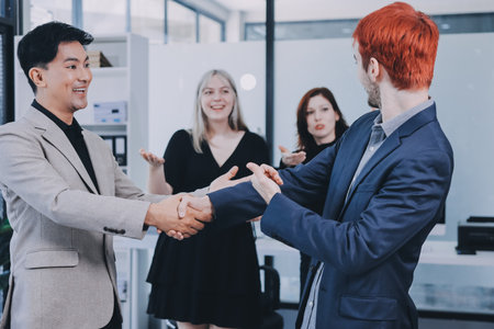 Meeting, partnership and business people shaking hands in the office for a deal, collaboration or onboarding. Diversity, professional and employees with handshake for agreement, welcome or greeting.の写真素材