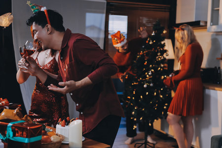 Festive Office Christmas Party with Delicious Food. A beautifully decorated office space with Christmas trees and festive lights, set up for a holiday party.の写真素材