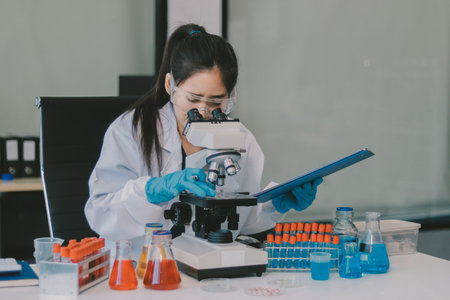 Portrait, science and happy woman on laptop in lab to research chemistry, test or innovation. Microscope, scientist and face of medical doctor in goggles for microbiology, healthcare or pharma studyの写真素材