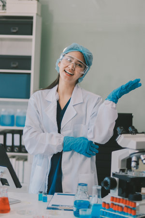 Portrait, science and happy woman on laptop in lab to research chemistry, test or innovation. Microscope, scientist and face of medical doctor in goggles for microbiology, healthcare or pharma studyの写真素材