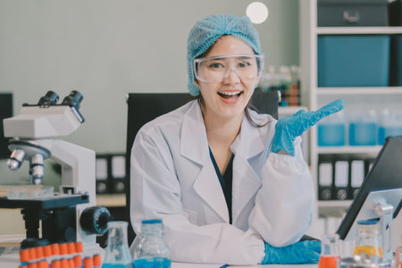 Portrait, science and happy woman on laptop in lab to research chemistry, test or innovation. Microscope, scientist and face of medical doctor in goggles for microbiology, healthcare or pharma studyの写真素材