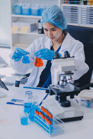 Portrait, science and happy woman on laptop in lab to research chemistry, test or innovation. Microscope, scientist and face of medical doctor in goggles for microbiology, healthcare or pharma studyの写真素材
