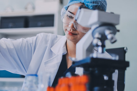 Portrait, science and happy woman on laptop in lab to research chemistry, test or innovation. Microscope, scientist and face of medical doctor in goggles for microbiology, healthcare or pharma studyの写真素材