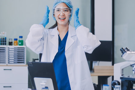 Portrait, science and happy woman on laptop in lab to research chemistry, test or innovation. Microscope, scientist and face of medical doctor in goggles for microbiology, healthcare or pharma studyの写真素材