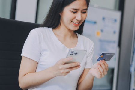Online payment, Hands of woman holding a credit card and using smart phone for online shoppingの写真素材
