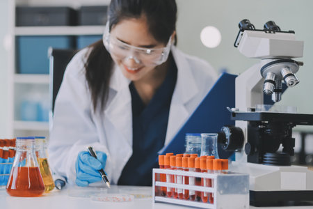 Portrait, science and happy woman on laptop in lab to research chemistry, test or innovation. Microscope, scientist and face of medical doctor in goggles for microbiology, healthcare or pharma studyの写真素材