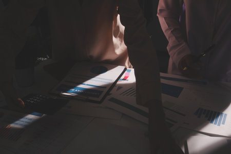 Above table with finance papers, graphs and big data during teamwork meeting with accounting or...