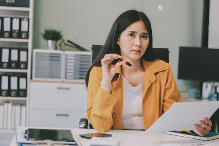 Business woman using calculator for math finance on wooden desk in office and business working background, tax, accounting, statistics and analytic research concept.の写真素材