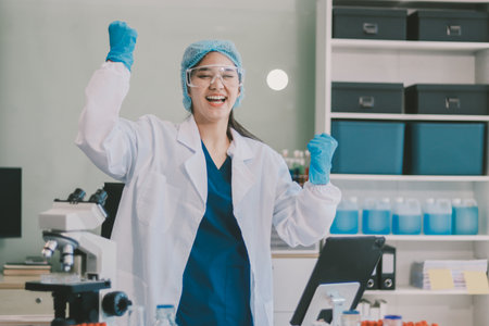 Portrait, science and happy woman on laptop in lab to research chemistry, test or innovation. Microscope, scientist and face of medical doctor in goggles for microbiology, healthcare or pharma studyの写真素材