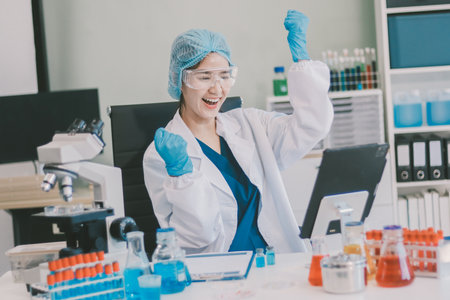 Portrait, science and happy woman on laptop in lab to research chemistry, test or innovation. Microscope, scientist and face of medical doctor in goggles for microbiology, healthcare or pharma studyの写真素材