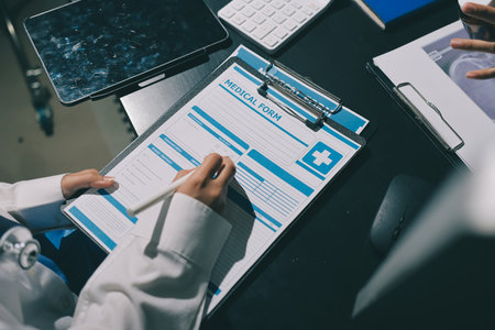 Two doctors and a female nurse meet at a table in the hospital, collaborating on medical tasks using...