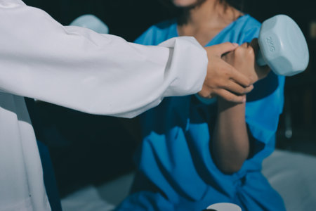 Physical therapist assisting a woman with dumbbell exercise