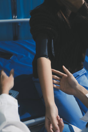Doctor examining young girl, measuring blood pressure, using medical blood pressure monitor. Concept...