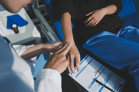 Man with abdominal pain, bloating, diarrhea goes to the doctor at medical clinic. Female doctor is diagnosing a patient abdominal pain in the examination room at the hospital.の写真素材