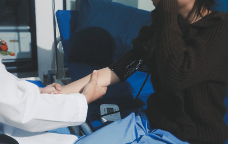 Doctor examining young girl, measuring blood pressure, using medical blood pressure monitor. Concept...