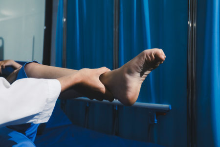 Asian male doctor examining foot of female patient sitting on bed in hospital room. Performing...