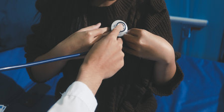 Caring doctor using stethoscope to examine patient heart during medical checkup